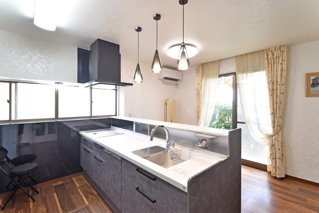 新設された対面キッチンのカウンター収納と、デザインを統一した背面の大型カップボード。見せる収納にこだわった事例。