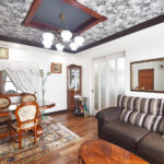 大竹市M様邸LDKリフォーム後。モノトーンの花柄アクセントクロスを施した折り上げ天井と、明るいホワイトの壁面でクラシックモダンな空間。