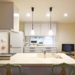 大竹市T様邸キッチンリフォーム後。向きを90度変更した対面式のペニンシュラキッチン。白を基調とした明るい空間。