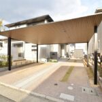 広島市Y様邸に設置されたYKK AP プレーンルーフ。木調の天井とブラックフレームがモダンな、デザイン性の高い2台用カーポート。