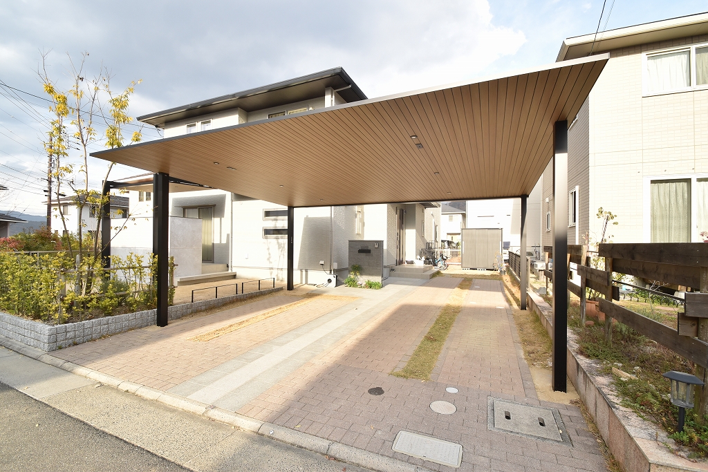 広島市Y様邸に設置されたYKK AP プレーンルーフ。木調の天井とブラックフレームがモダンな、デザイン性の高い2台用カーポート。