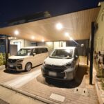 YKK AP プレーンルーフの夜間施工事例。内蔵されたダウンライトが木目の天井を照らし、幻想的で高級感のある広島市Y様邸の駐車場。